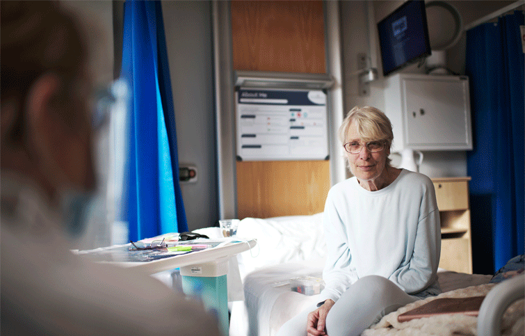 Sharon sitting on a bed at the hospice
