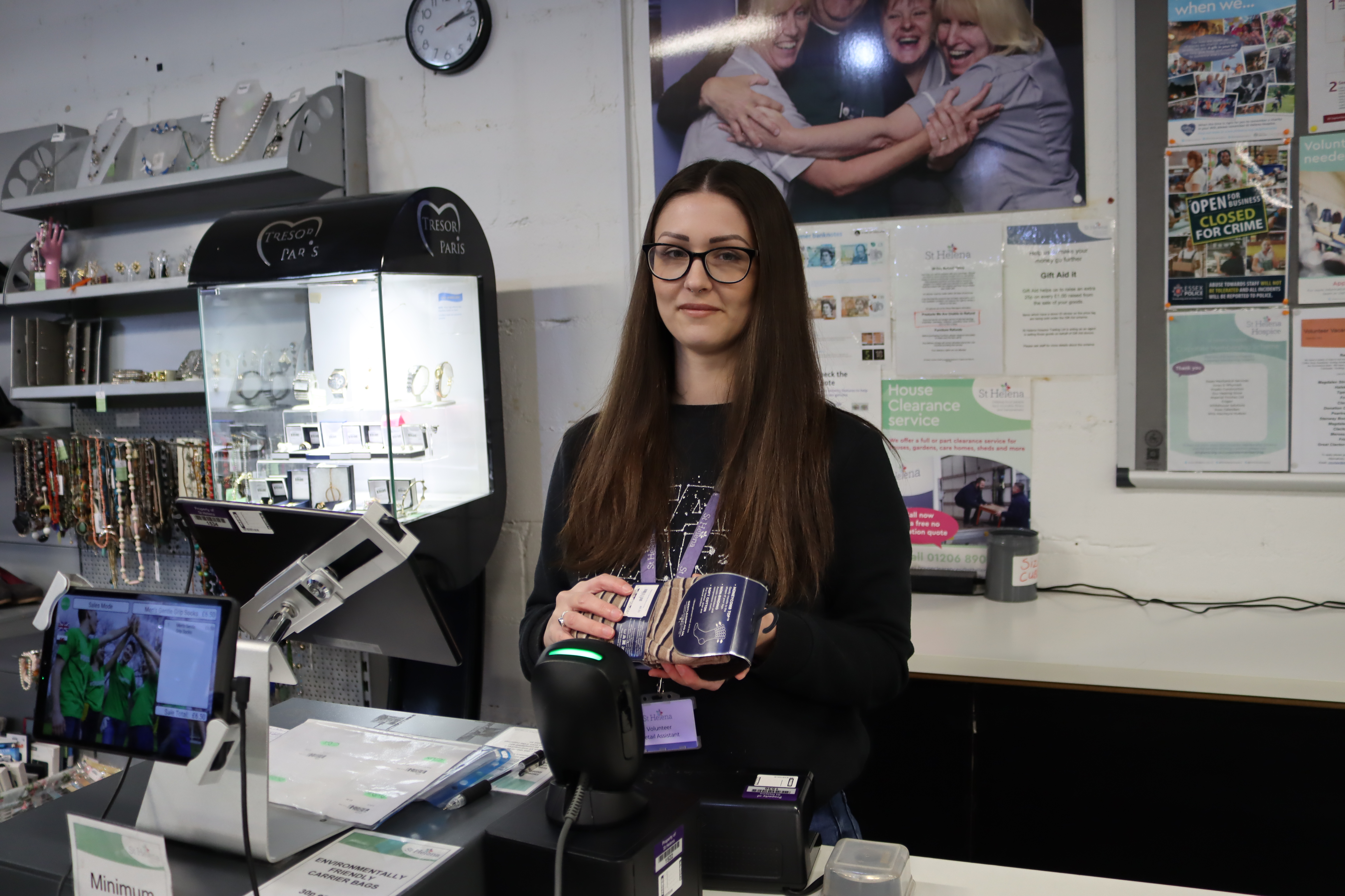 A female volunteer scanning an item through the till
