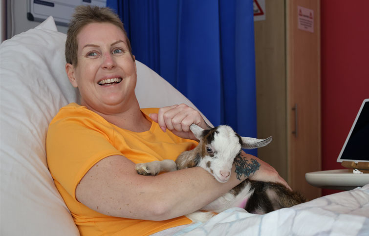 Image: Victoria holding a kid goat at the hospice
